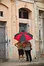 2 Cuban Ladies Chat under Colourful Umbrella