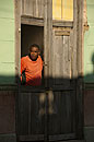 Cuban Man in Orange Top looking Out Doorway