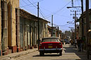 Red Car Driving in a Trinidad Cuba Street