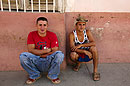2 Young Cuban Men Crouching against a Wall